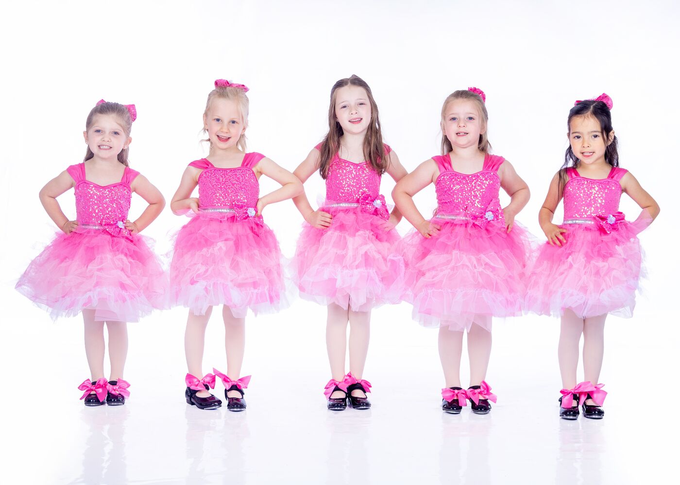 Young tap dancers in pink tutus and tap shoes