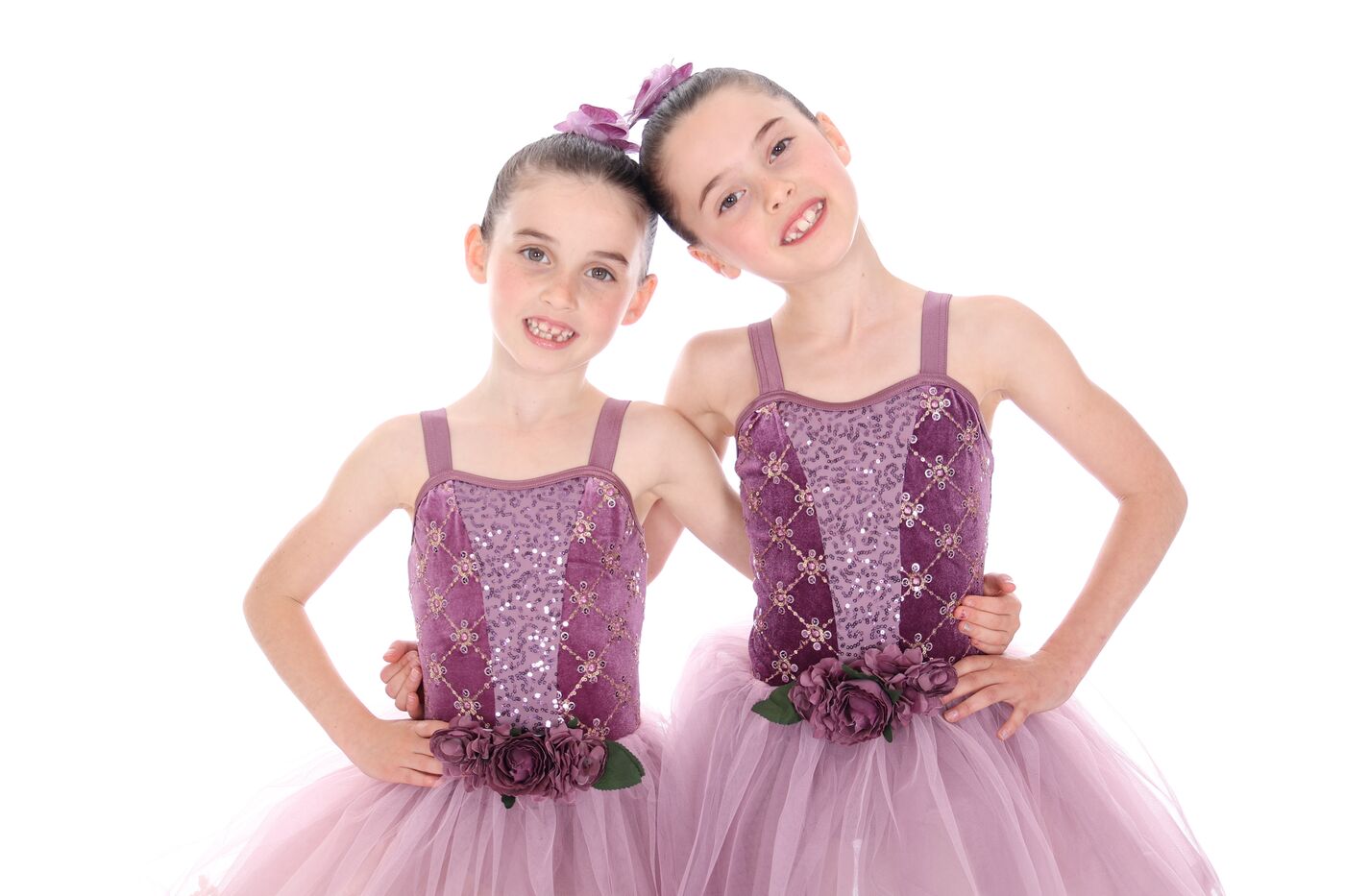 Two ballet dancers in matching purple costumes smiling together
